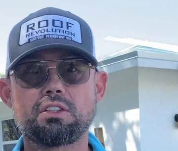 Roof Revolution team member in a Roof Revolution cap and sunglasses